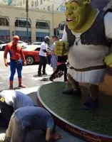 2 guys bowing down to shrek while spider man watches